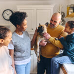 Family and boy with Down syndrome stroking pet dog French bulldog