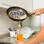 A person pouring cooking grease into a plastic container