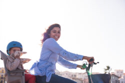 Eco-friendly Family. Mother riding on a bicycle with young kid